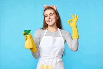 woman holding detergent sprayer and showing ok gesture