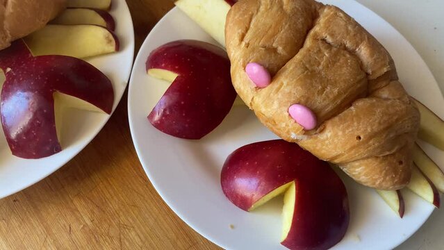 Creative kids breakfast, Croissants and apple crabs. Green and pink eyes Food preparation and decoration. Close up. High quality 4k footage