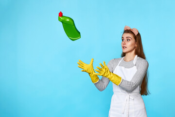 woman in rubber gloves catches flying bottle of detergent
