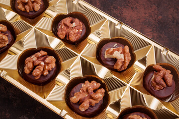 Close up of homemade with dark chocolate pralines filled with walnuts and  marzipan