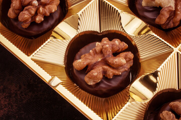 Close up of homemade with dark chocolate pralines filled with walnuts and  marzipan
