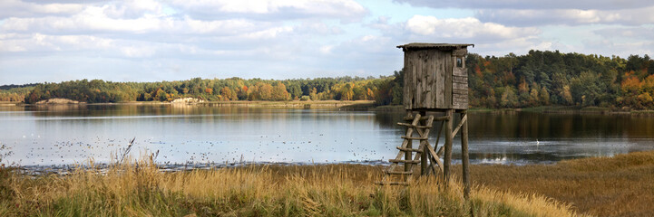 Observation tower hunting pulpit,  autumn landscape on the , blue sky and dried grass.