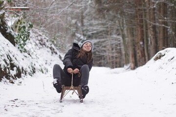 Winterzeit Mädchen fährt schnell den Berg auf einem Schlitten herunter
