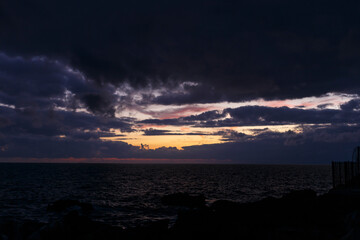 Colorful clouds of a seascape sunset in Genova, Italy. No people are visible. - obrazy, fototapety, plakaty