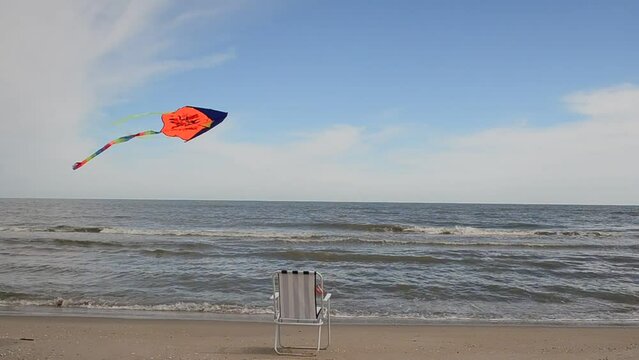 Chaise lounge on the beach, the sea and a kite. Summer