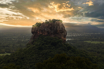 Sunset with view from Pidurangala mountain to Sigiriya Lion Rock in Sri Lanka. Landscape panorama. After climb up the hill for tourists for wonderful view point to Lion Rock.