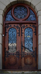 door. Old wooden entrance doors with a brass handle in the city. Arched door. A beautiful street door with an arch