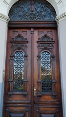 door. Old wooden entrance doors with a brass handle in the city. Arched door. A beautiful street door with an arch
