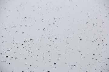 Closeup of rain drops on glass window pane, rainy day window background