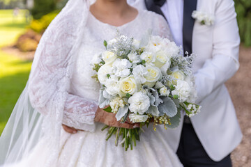 Afghani bride's holding wedding bouquet, white flowers hands close up