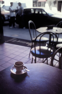 a espresso cup sits on a table in a cafe.