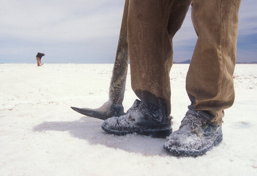 Salt miners digging up the ground in Bolivia.