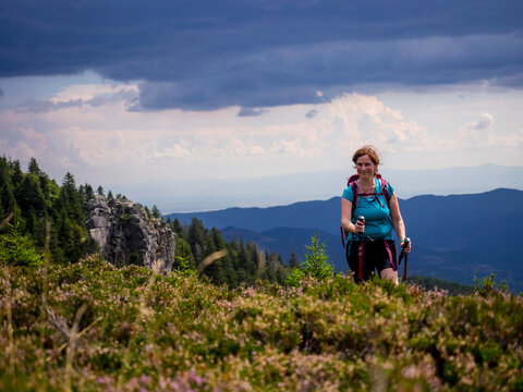 Women hiking on meadow towards valley at Col de la Schlucht In the Vosges, Alsace, France