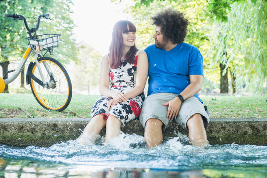Happy couple splashing water at Eisbach River
