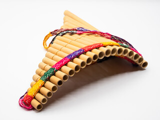 Pan flute with colorful band around against white background. © Karlsson Photo