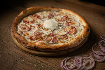 delicious pizza with ham, onions and fried eggs in the middle