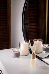 Air freshener in a glass bottle and scented candles in candle holders. Home atmosphere. Fragrances for the home