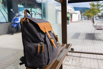 Tourist beautiful backpack on the bench stop, the traveler is waiting for transport.