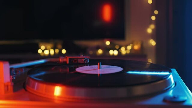 Vinyl record on retro music player close-up in blue and red neon light
