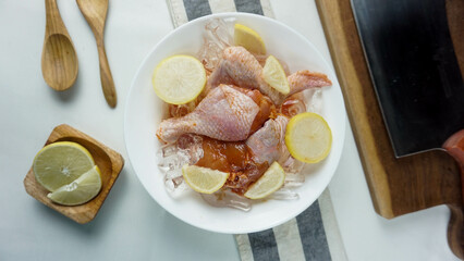 Chicken Meat on full of ice and lemon on white plate and spoon, napkin and knife as decoration