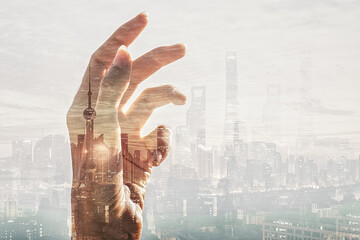 Fototapeta na wymiar Conceptual photo of hand on a city background. High skyscrapers. Success. Business