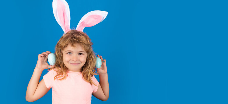 Happy Easter. Kids Boy In Bunny Ears Hunting Easter Eggs Isolated On Blue Background. Wide Photo Banner For Website Header Design.