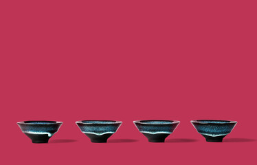 Dark blue clay cups lined on trendy magenta color of year 2023 background. Creative minimalist tea ceremony concept. Copy space.