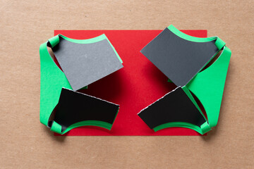 abstract folded and partly curled green and black paper card stencils with somewhat geometric...