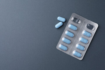 Pills and space for text on dark gray background, top view. Potency problem