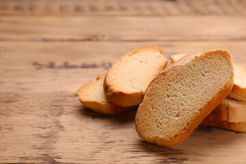 Tasty hard chuck crackers on wooden table, closeup. Space for text