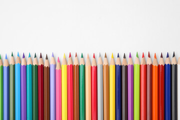Colorful wooden pencils on white background, flat lay. Space for text