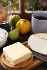 Tasty homemade butter, bread slices and tea on wooden table