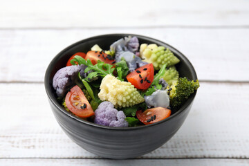 Delicious salad with cauliflower and tomato on white wooden table, closeup