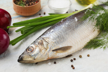 Delicious salted herring and ingredients on wooden table, closeup