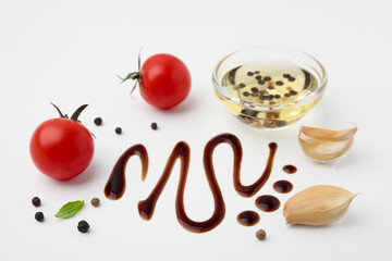 Organic balsamic vinegar and cooking ingredients on white background, flat lay
