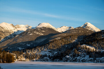 A snow range of mountains near frozen Green Lake with Wedge Mountain and and other peaks, near Whistler BC, Canada.
