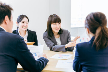 オフィスで楽しい会議・ミーティング・打ち合わせをするアジア人ビジネスウーマン（提案・営業・説明）
