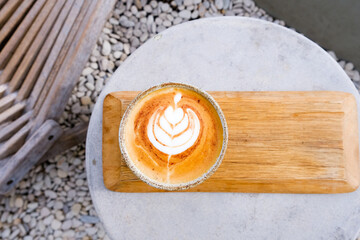 Top view of cup of cappuccino with beautiful latte art on concrete table.