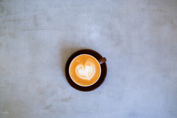 top view of cup of cappuccino with beautiful latte art on concrete background.