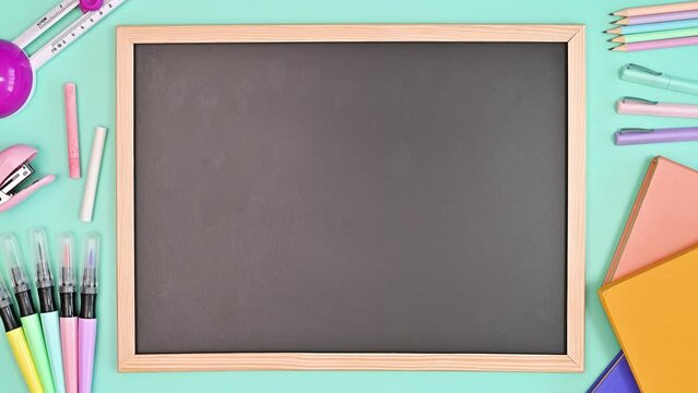 Blackboard and school stationery appear on blue background. Copy space. Stop motion