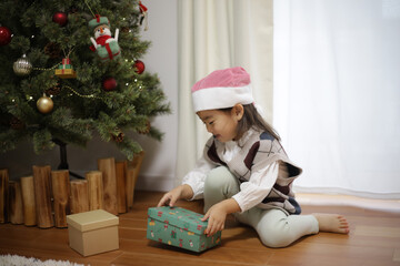 Obraz na płótnie Canvas クリスマスプレゼントを開ける女の子