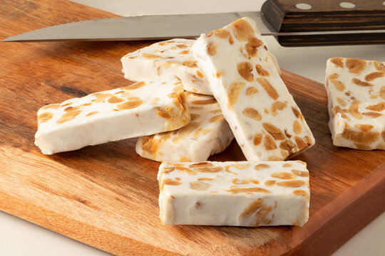 Traditional square of nougat on cutting board. Selective focus.
