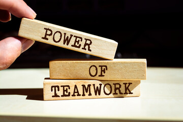 Wooden blocks with words 'POWER OF TEAMWORK'.