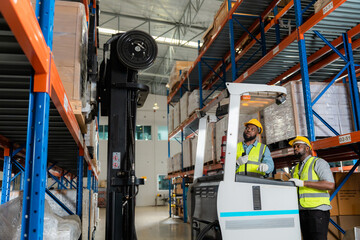 Two african workers talking working in a warehouse Organize the product system with a forklift truck.