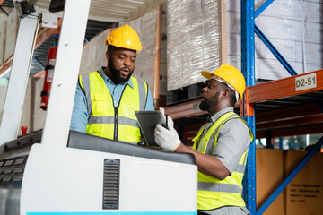 Two african workers talking working in a warehouse Organize the product system with a forklift truck.