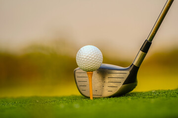 Golf clubs and golf balls on a green lawn in a beautiful golf course.