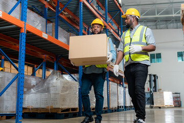 Two African workers talking while working in a warehouse.