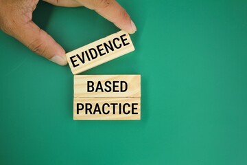 hand holding a wooden board with the word Evidence-based practice. the concept of evidence-based practice