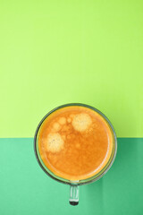 glass of hot black coffee put on green background