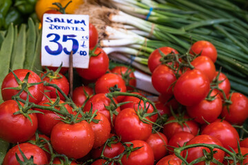 bunch of tomatoes among vegetables in the greengrocer,